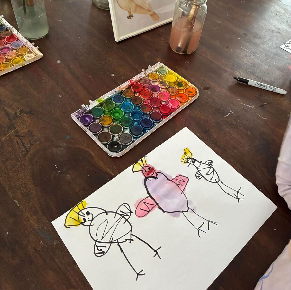 A photograph of a child&rsquo;s painting of 3 figures